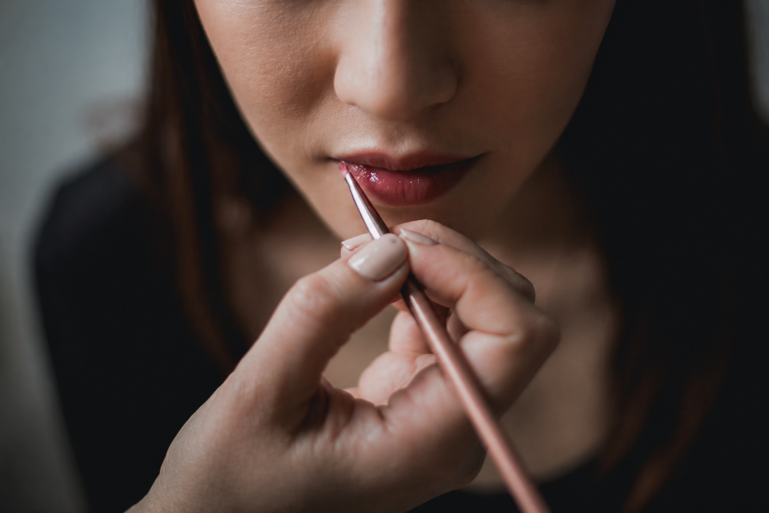 Makeup artist at Moxie putting on lipstick