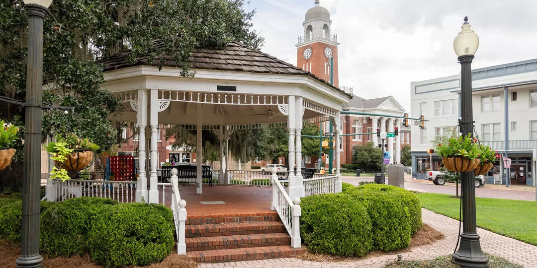 Gazebo in a park with a clock tower and buildings in the background Bainbridge